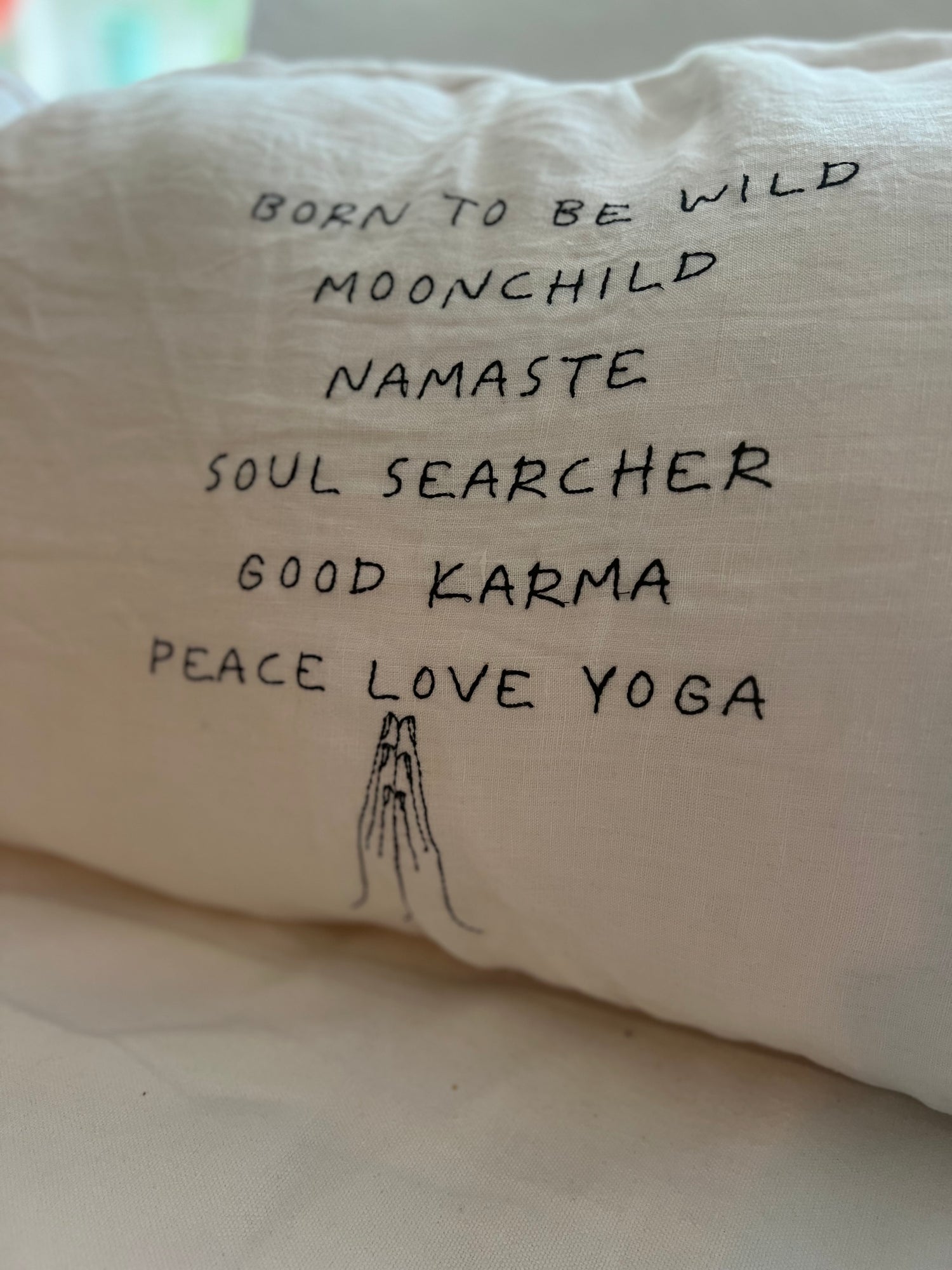 Hand embroidered text on a big linnen pillow 90 x 50 centimeter