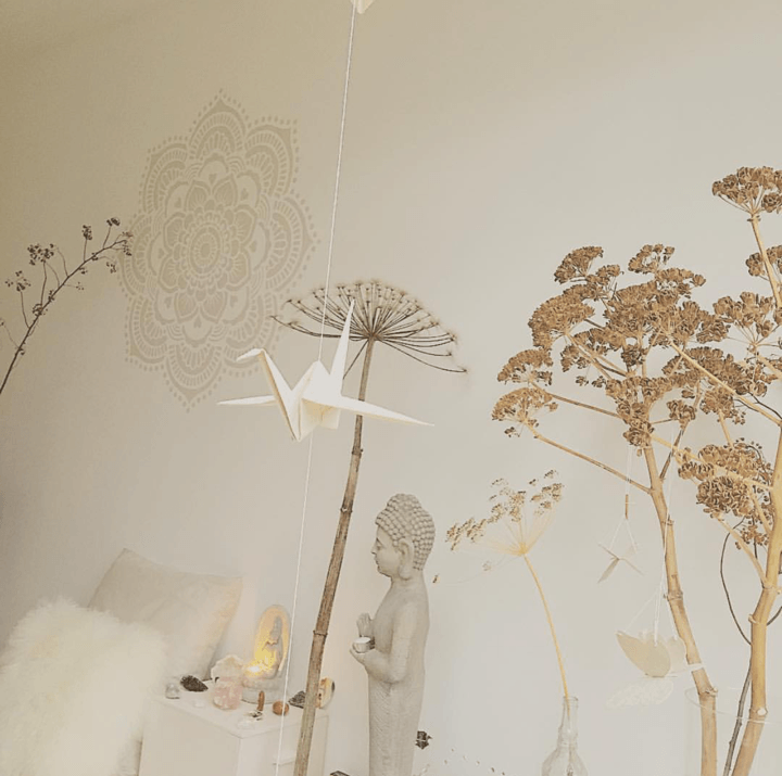 Large beige mandala wall stencil with intricate floral and circular patterns on a light wall above neutral-toned decor.