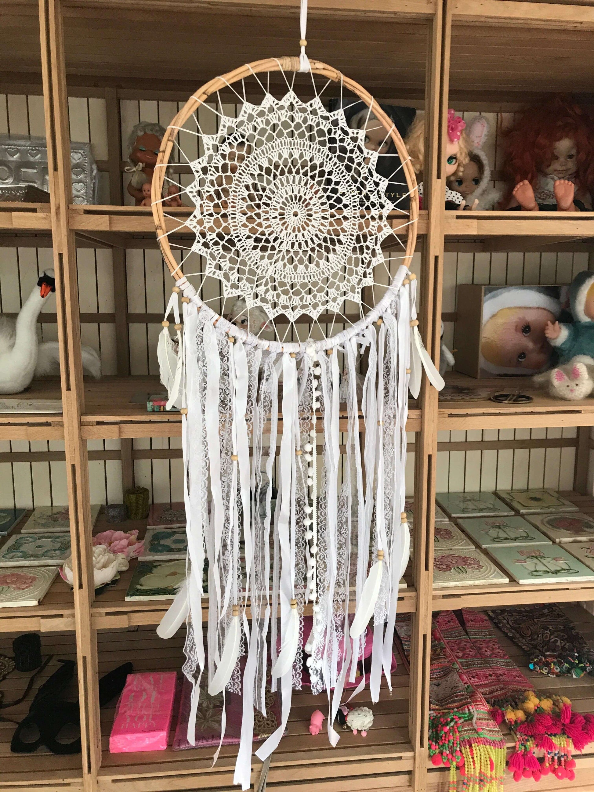 Handmade white dreamcatcher with intricate lace center, white ribbons, and feather accents, 52cm diameter.