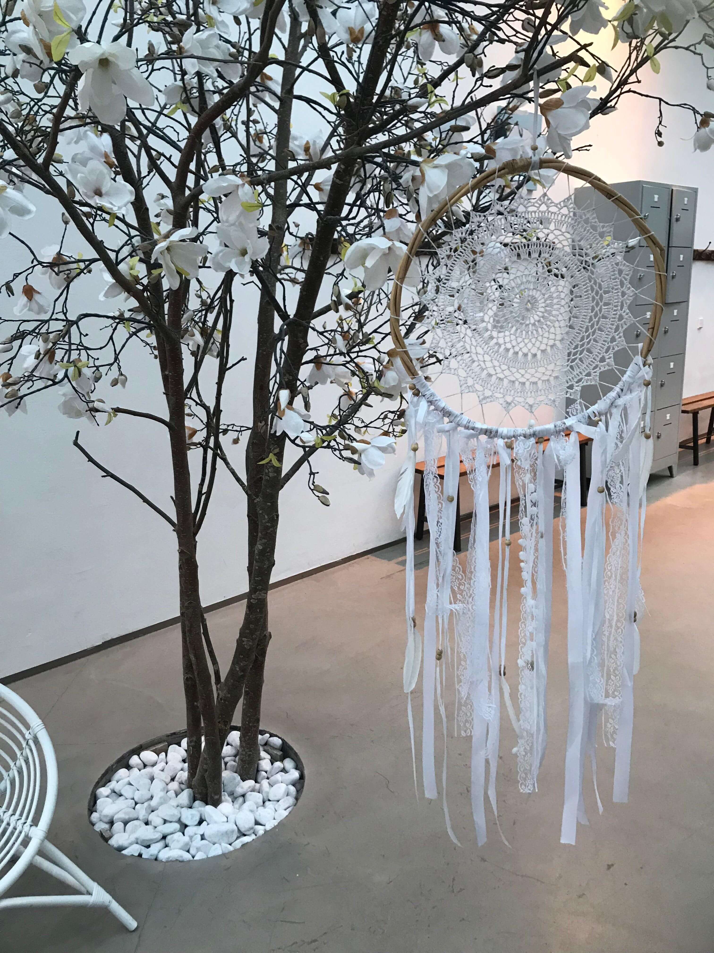Handmade white dream catcher 52cm with intricate lace web and long flowing ribbons hanging from a tree branch.