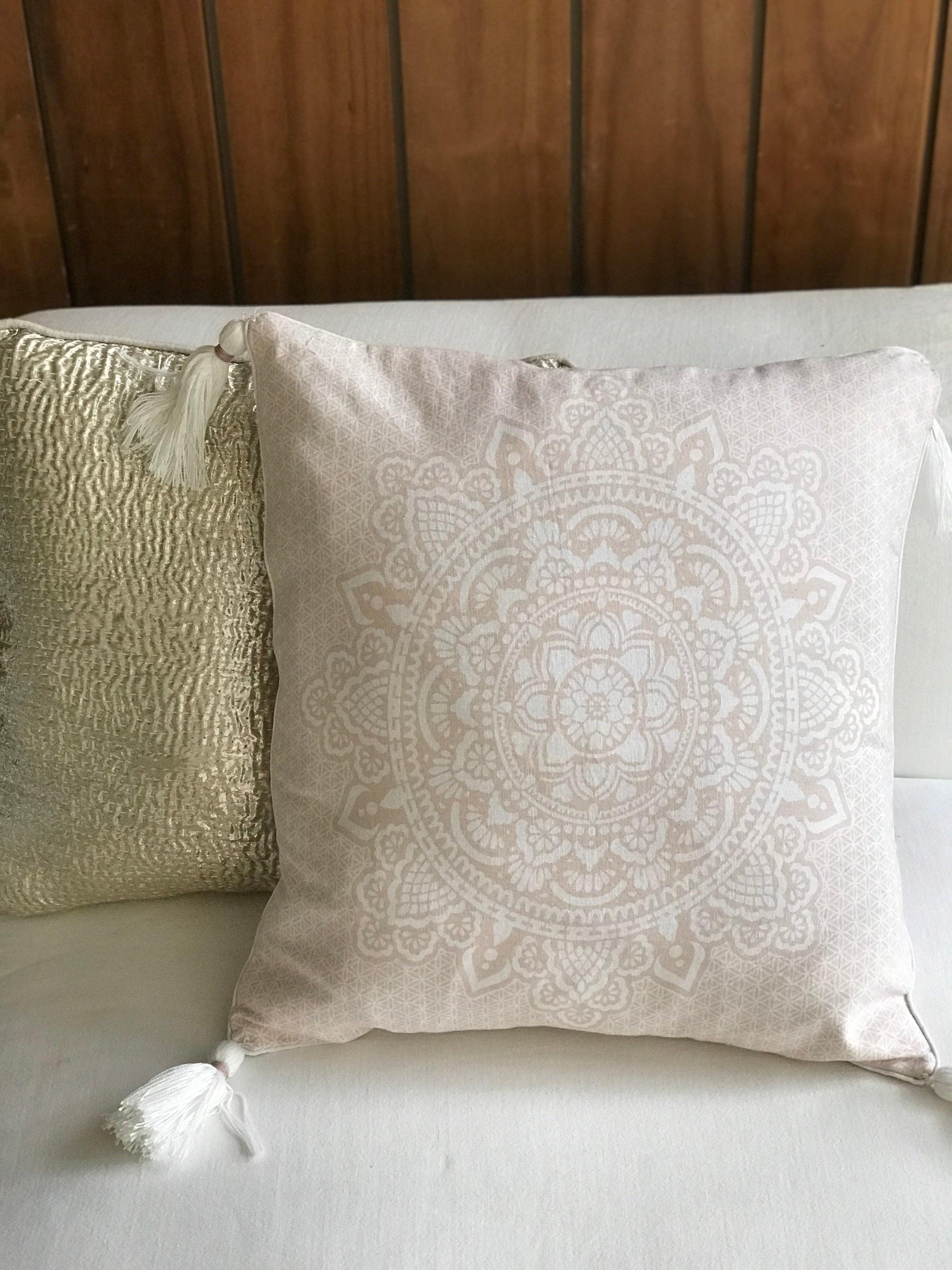 Soft pink mandala cushion cover 50x50 cm with tassels on white sofa.