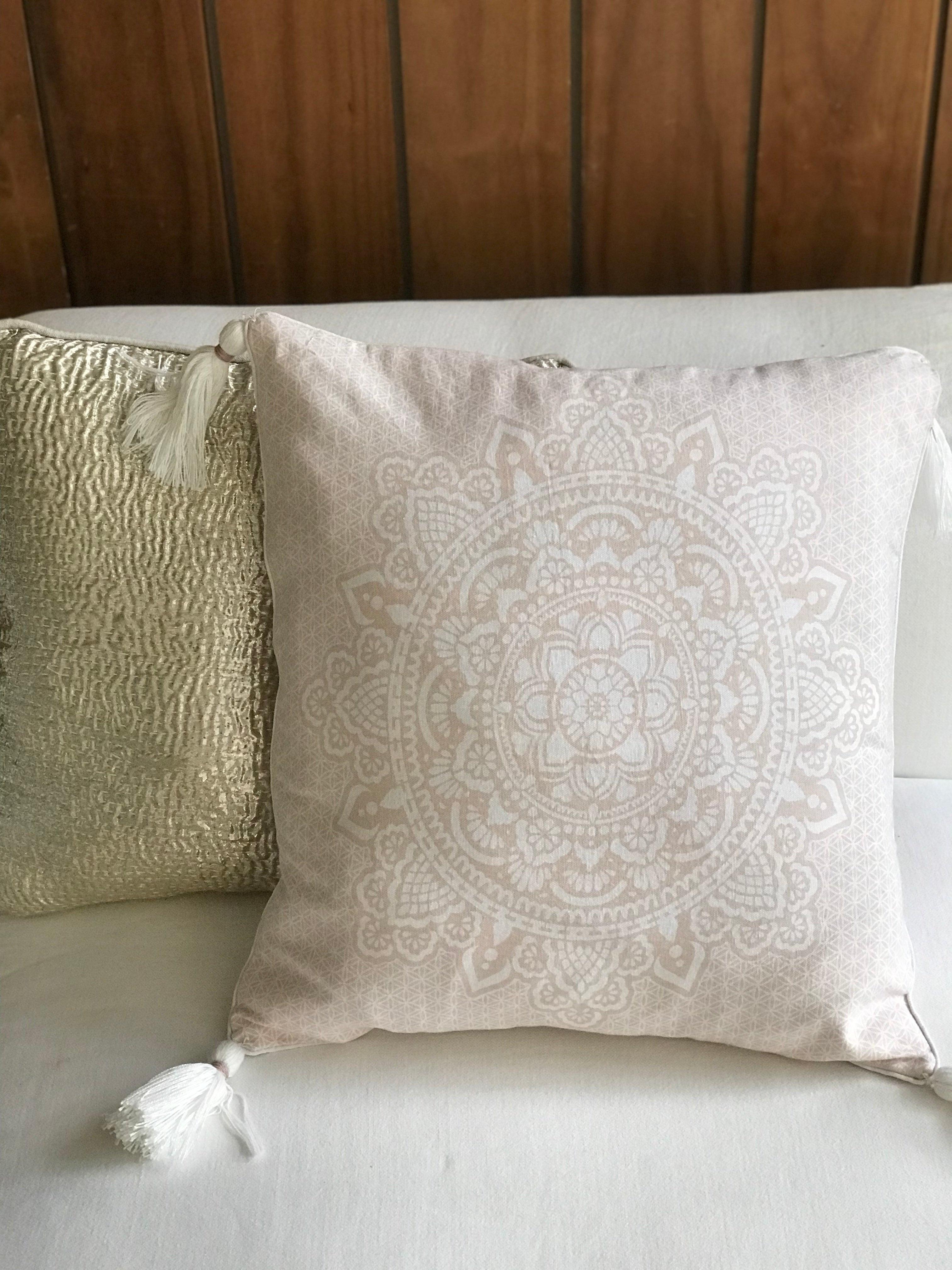 Soft pink mandala cushion cover 50x50 cm with tassels on white sofa.