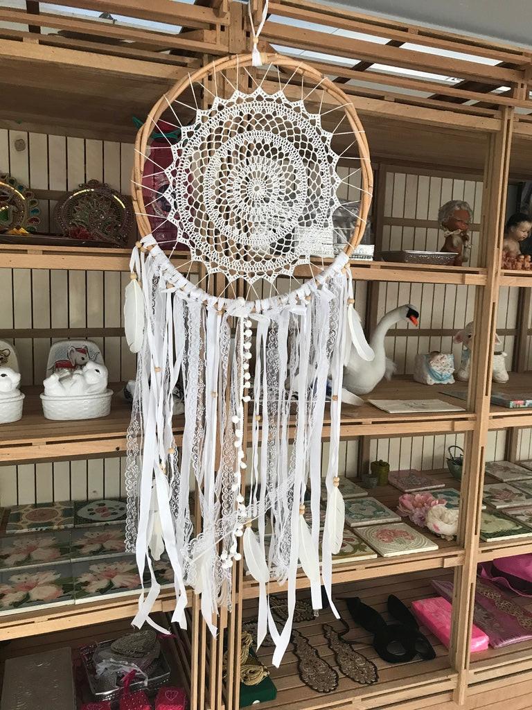 White rattan dream catcher 32cm with intricate crochet center and cascading fabric strips.